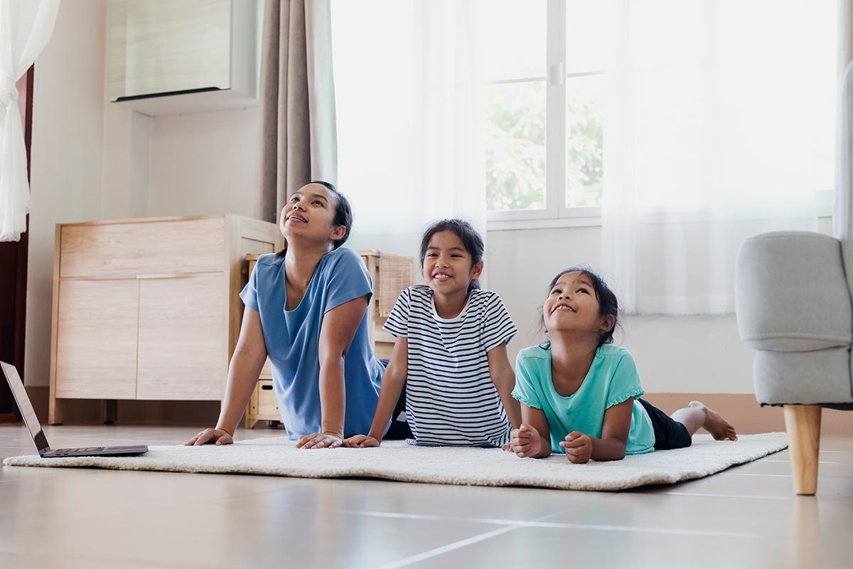 Uma família se exercitando dentro de casa.
