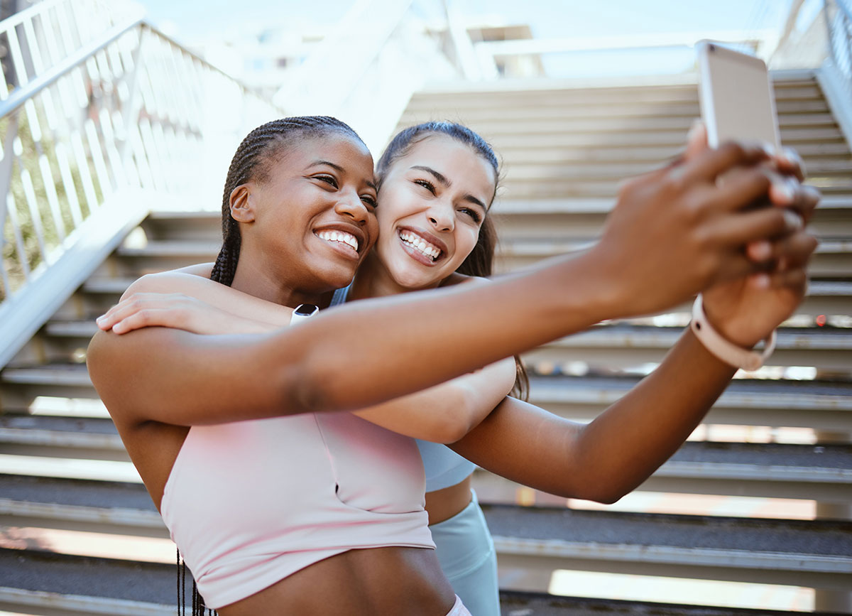Duas pessoas fazendo uma selife ao ar livre.