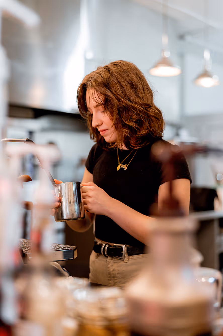A barista making a latte.