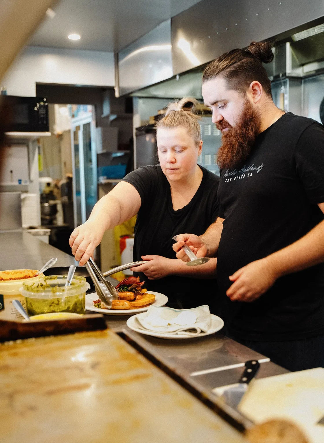 Two chefs plating at the pass