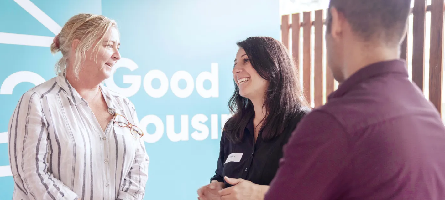 Smiling happy people with the Good housing logo in the background