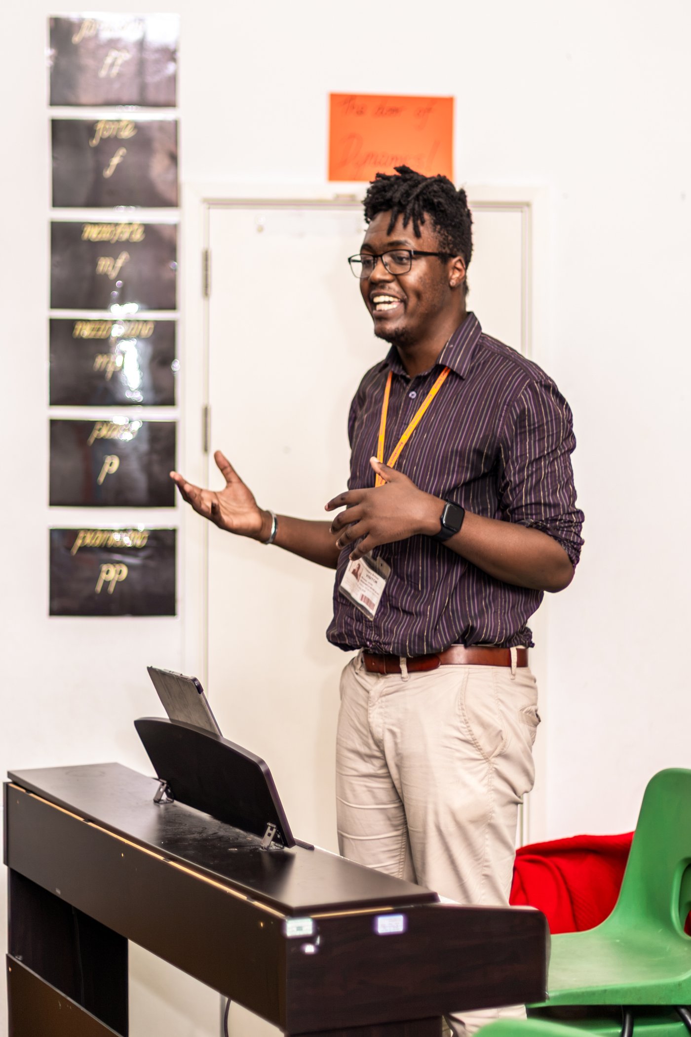 A teacher talks to pupils from beside a keyboard during a demonstration assembly