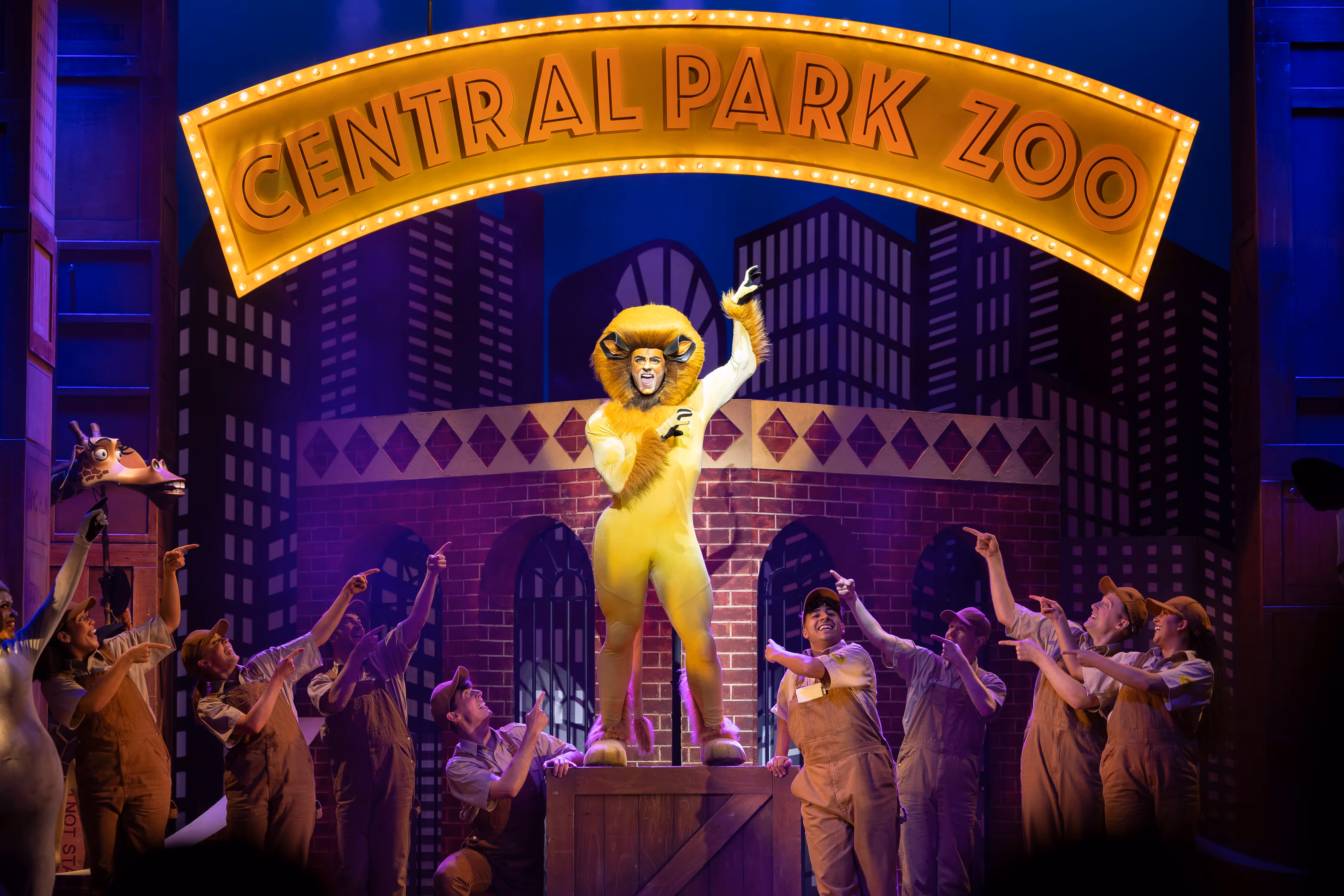 Performers dressed as Alex the Lion and Marty the Zebra from Madagascar The Musical dancing on stage in Wales Millennium Centre