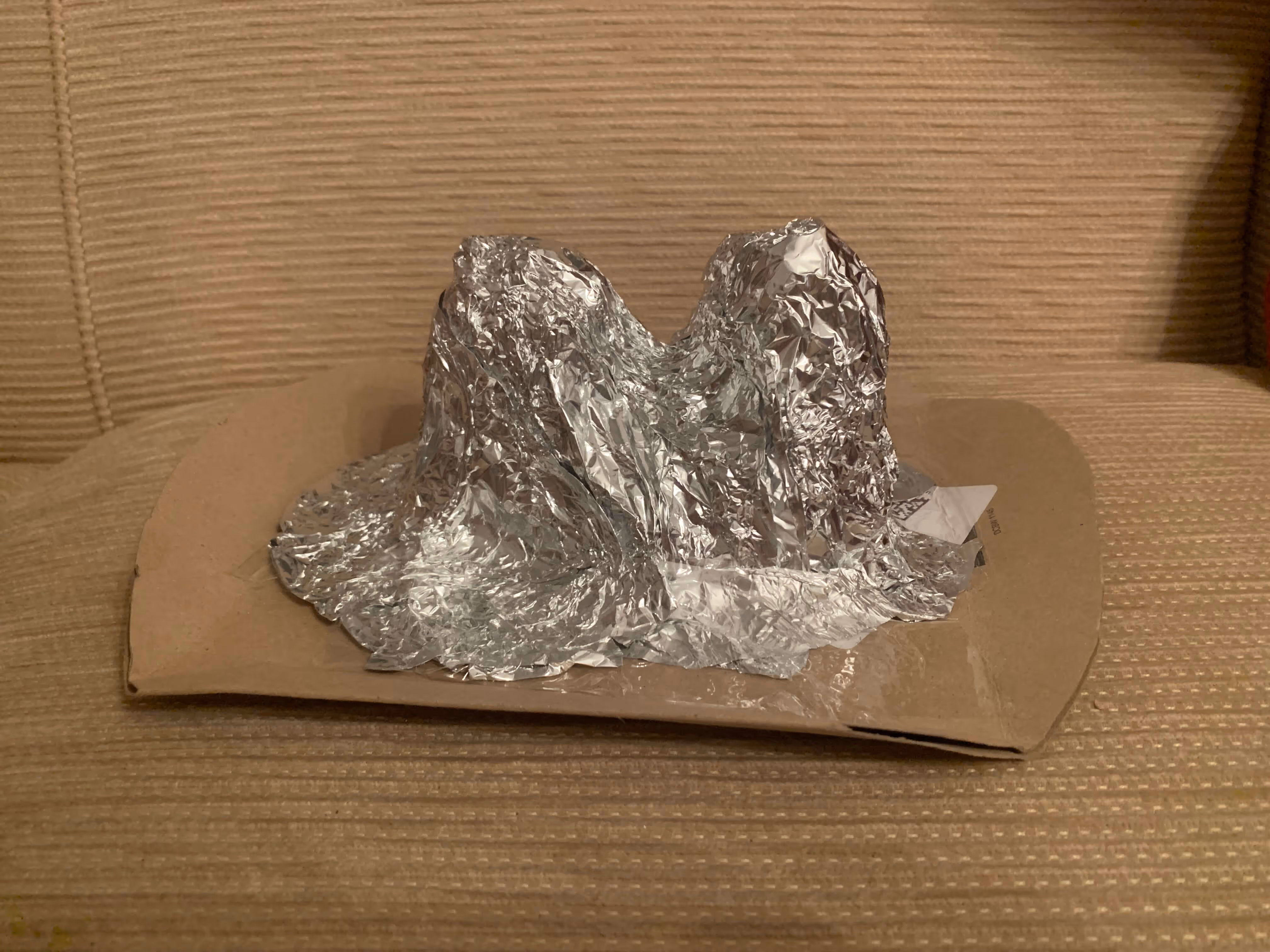 Attaching black felt facial features to the red Mr. Strong costume box.