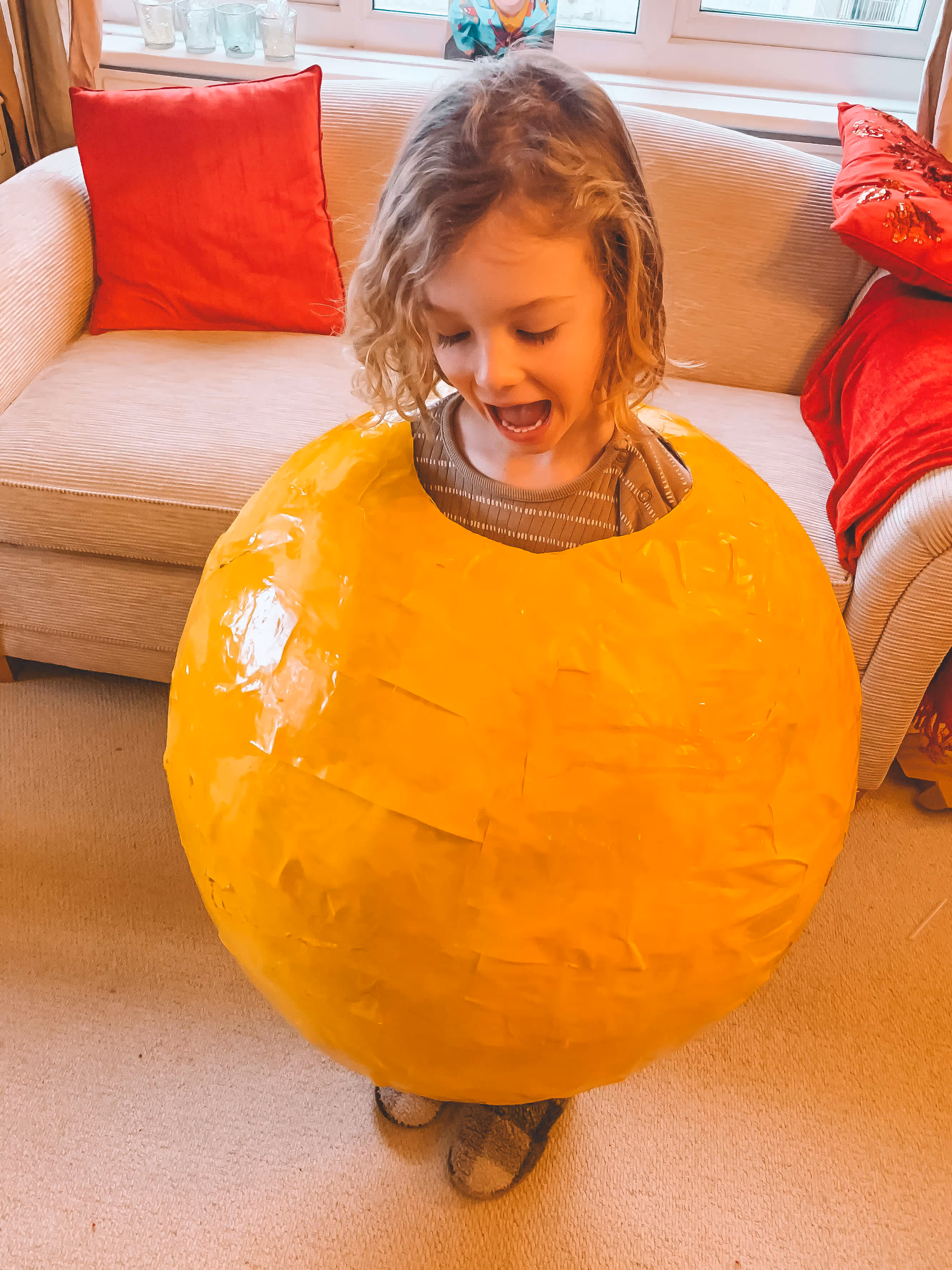 A DIY Mr. Happy costume with pencil-marked head and arm holes being cut out. | Mother Of Grom