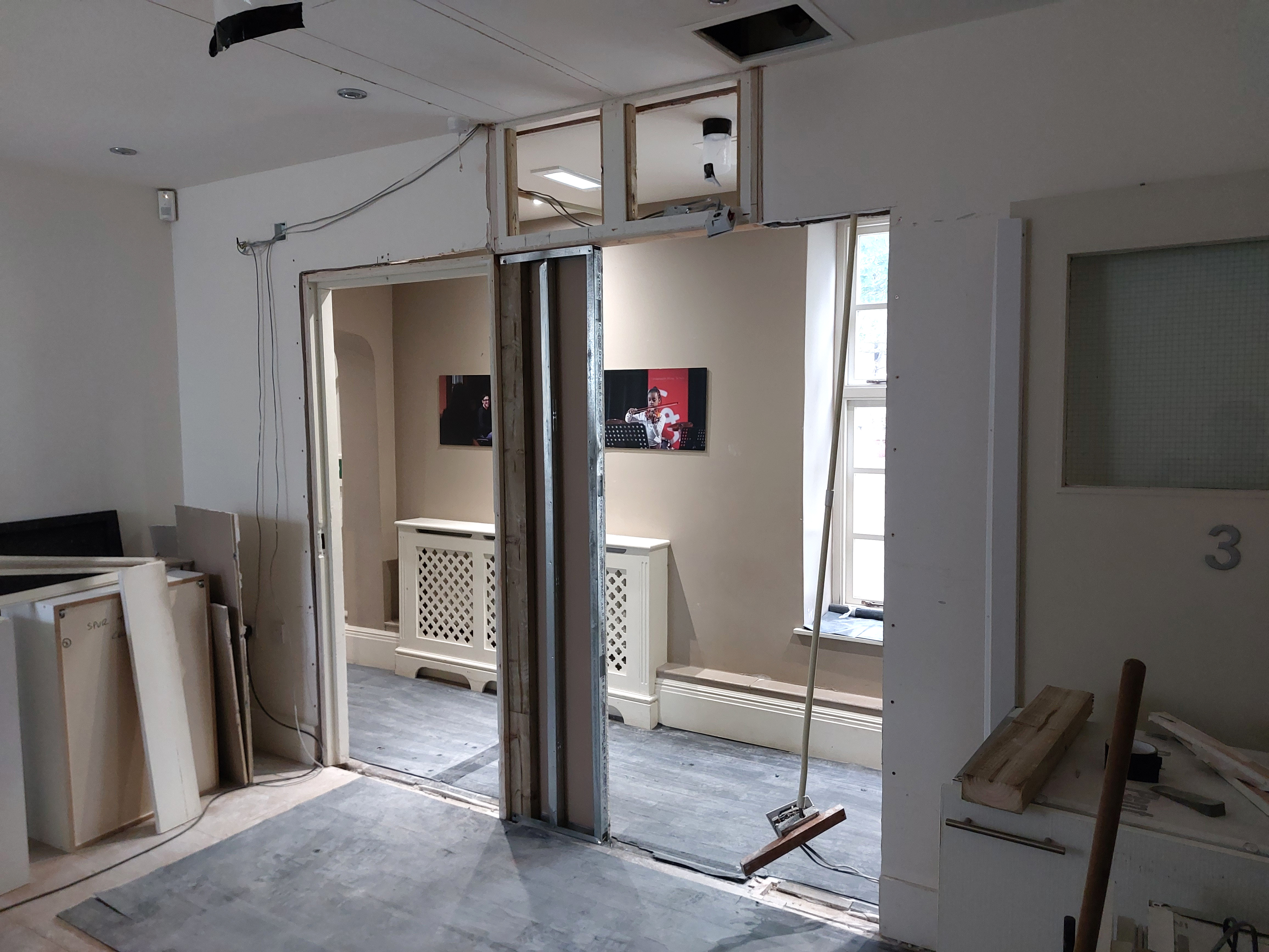 An exposed timber and metal partition frame between rooms during building work at The Stables.
