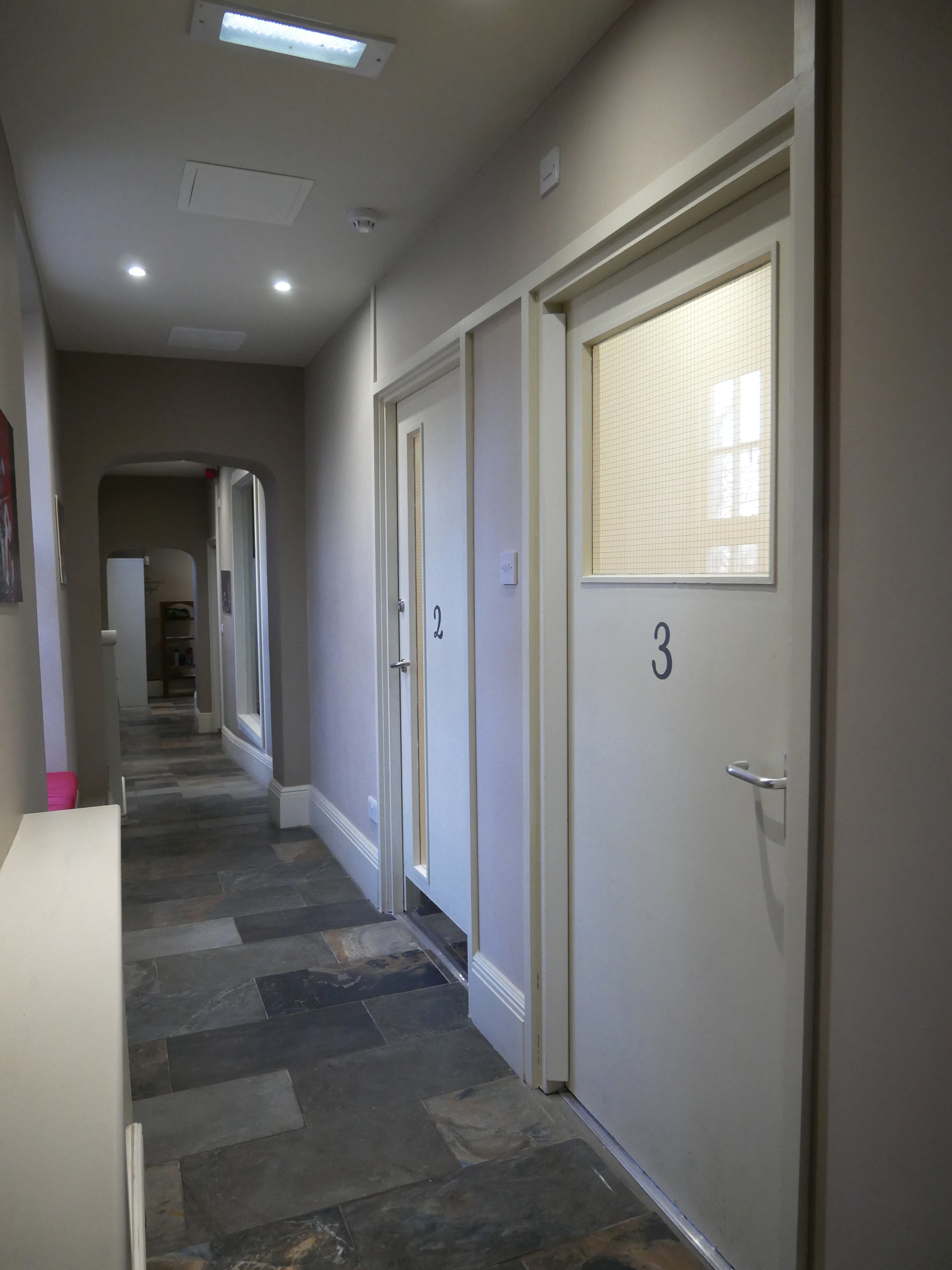 The finished corridor at The Stables, with numbered doors to teaching rooms two and three.