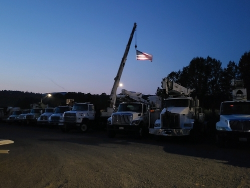 Utility Truck fleet at Northeast Electric with American flag.