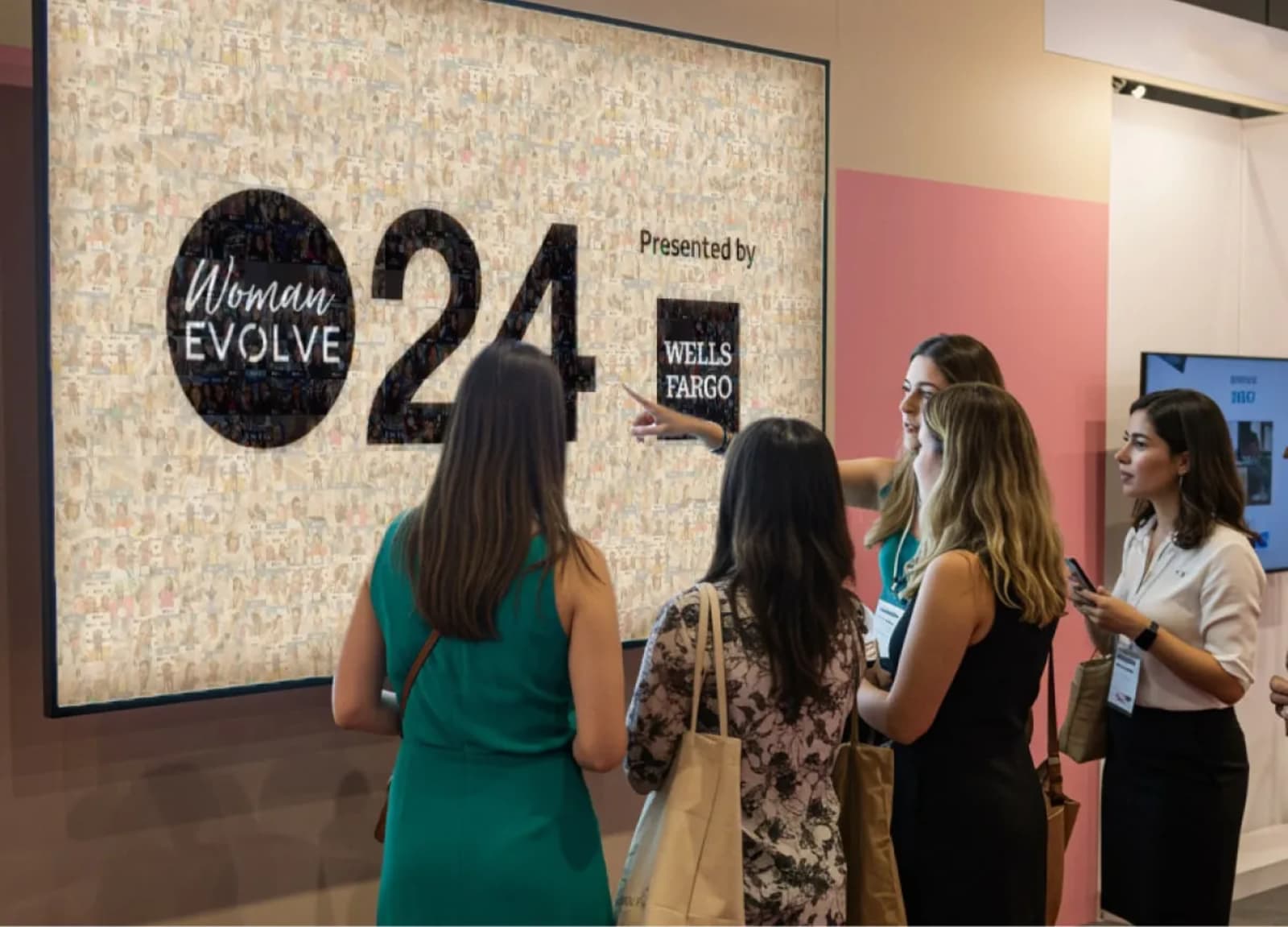 Attendees viewing a branded UGC mosaic wall display at a conference event