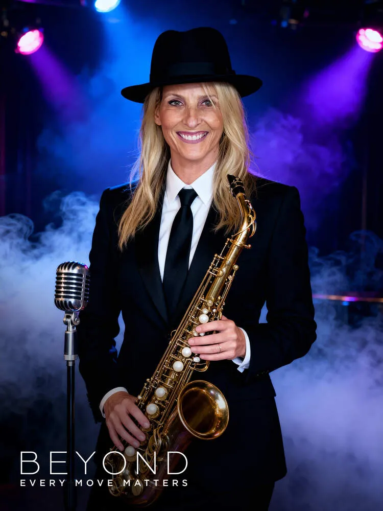 AI photo of a guest in a black suit and fedora holding a saxophone on a smoky stage, with Beyond event branding