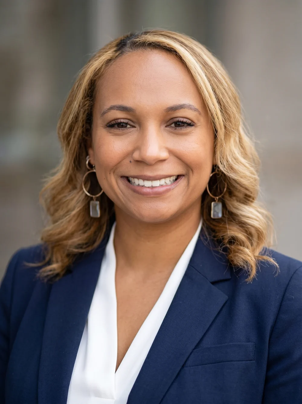 AI-enhanced professional headshot of a smiling guest in a navy blazer