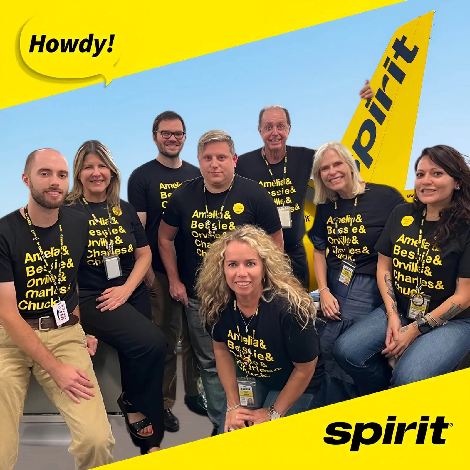 Photo booth snapshot of a Spirit Airlines team posing with a Howdy speech bubble on a yellow frame