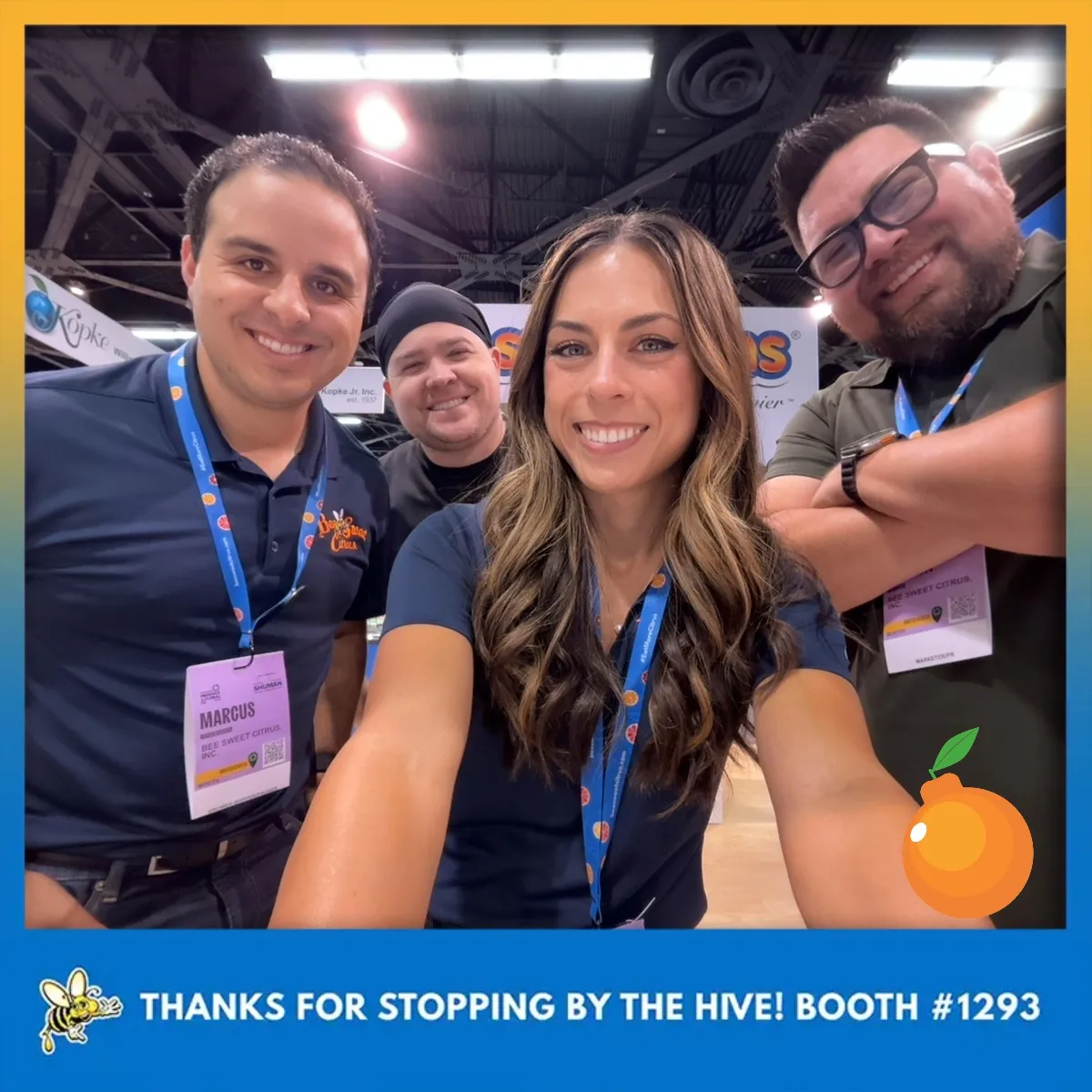 Photo booth snapshot of four teammates at a trade show booth with a Thanks for Stopping by the Hive banner