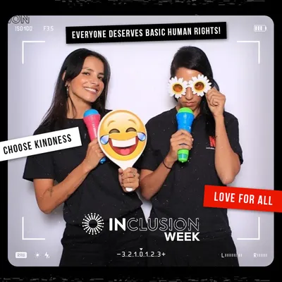 Photo booth snapshot of two guests with emoji props on an Inclusion Week frame reading Everyone Deserves Basic Human Rights