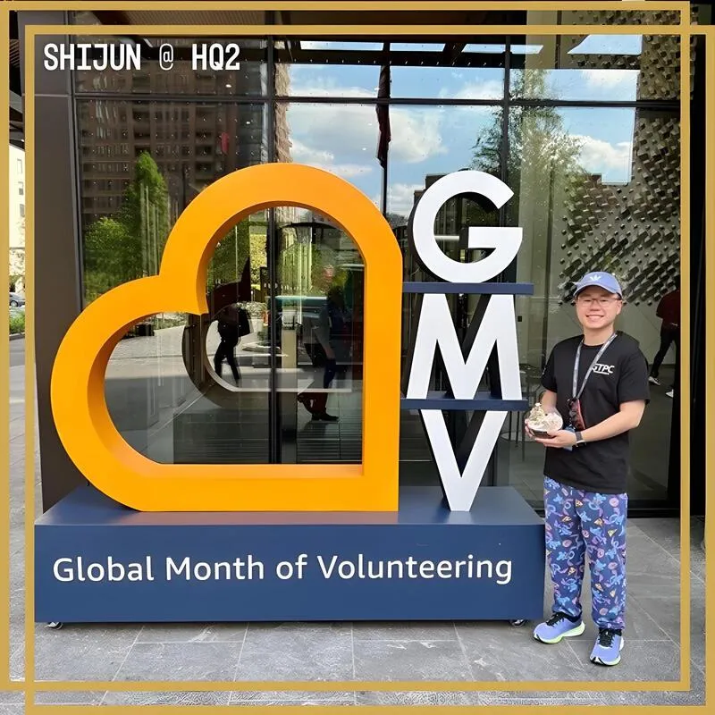 Photo booth snapshot of a guest beside a giant heart sculpture on an Amazon Global Month of Volunteering frame at HQ2
