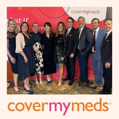 Photo booth snapshot of nine guests in formal wear on a CoverMyMeds gala frame