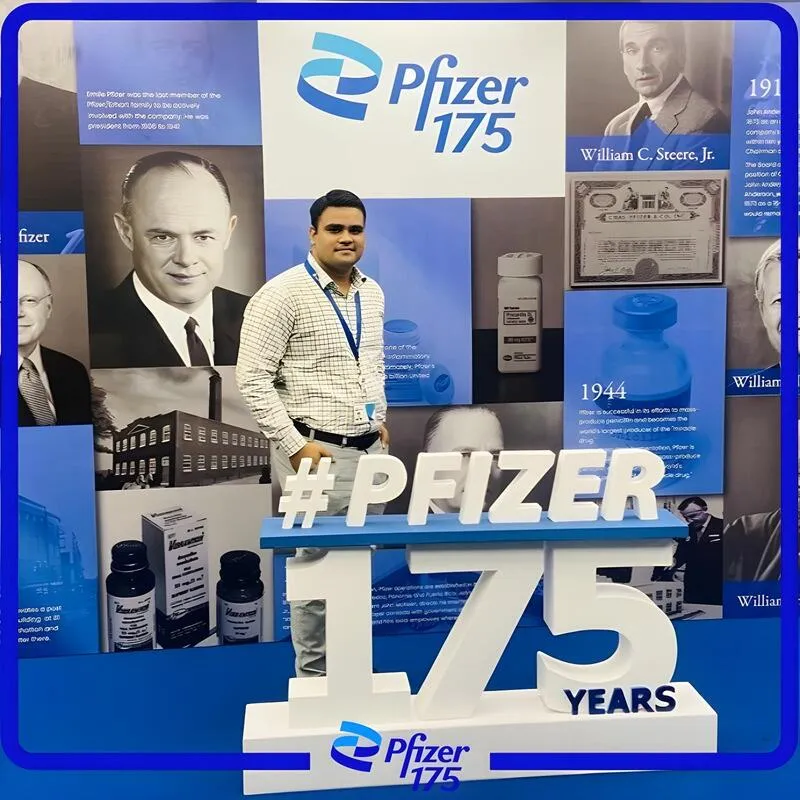 Photo booth snapshot of a guest beside a Pfizer 175 Years display wall