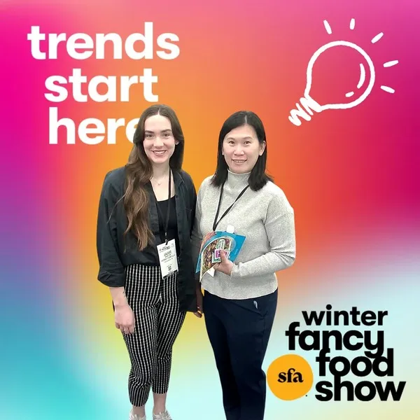 Photo booth snapshot of two guests on a Winter Fancy Food Show frame reading trends start here