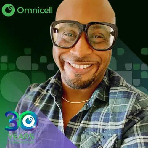 Photo booth snapshot of a guest in glasses smiling on an Omnicell 30 years frame