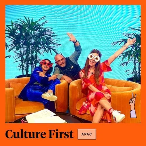 Photo booth snapshot of three guests celebrating on orange couches on a Culture First APAC frame