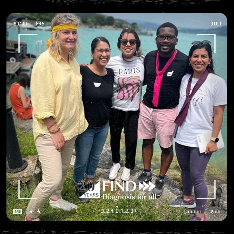 Photo booth snapshot of five teammates by a lake on a FIND 20 Years Diagnosis for All frame
