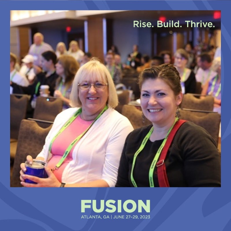 Photo booth snapshot of two guests in the audience on a Fusion Atlanta Rise Build Thrive frame