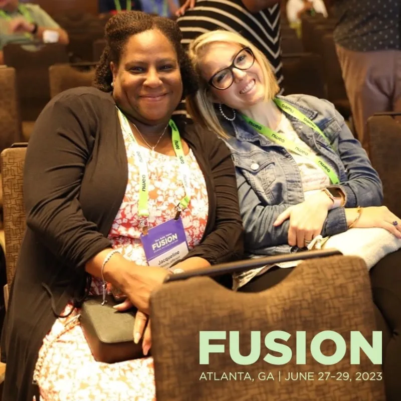 Photo booth snapshot of two guests seated in the audience on a Fusion Atlanta frame