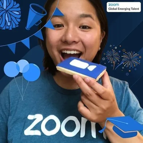Photo booth snapshot of a guest biting a Zoom logo cookie on a Global Emerging Talent frame