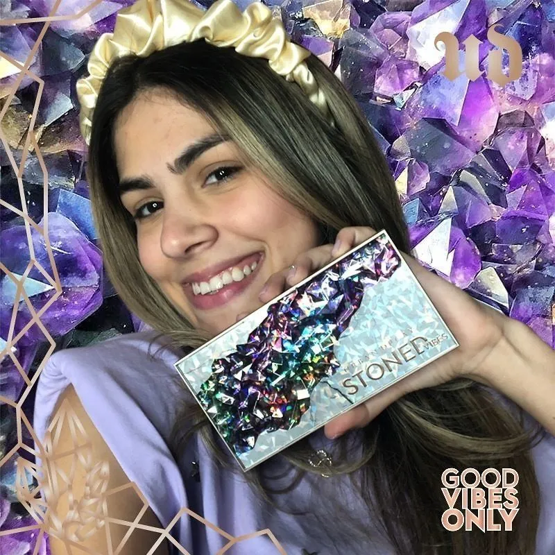 Photo booth snapshot of a guest holding an Urban Decay Stoned palette on an amethyst Good Vibes Only frame
