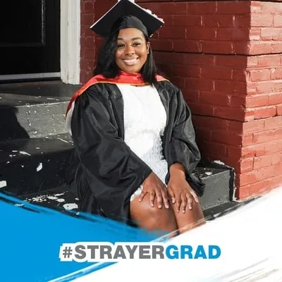 Photo booth snapshot of a graduate in cap and gown on a Strayer Grad frame