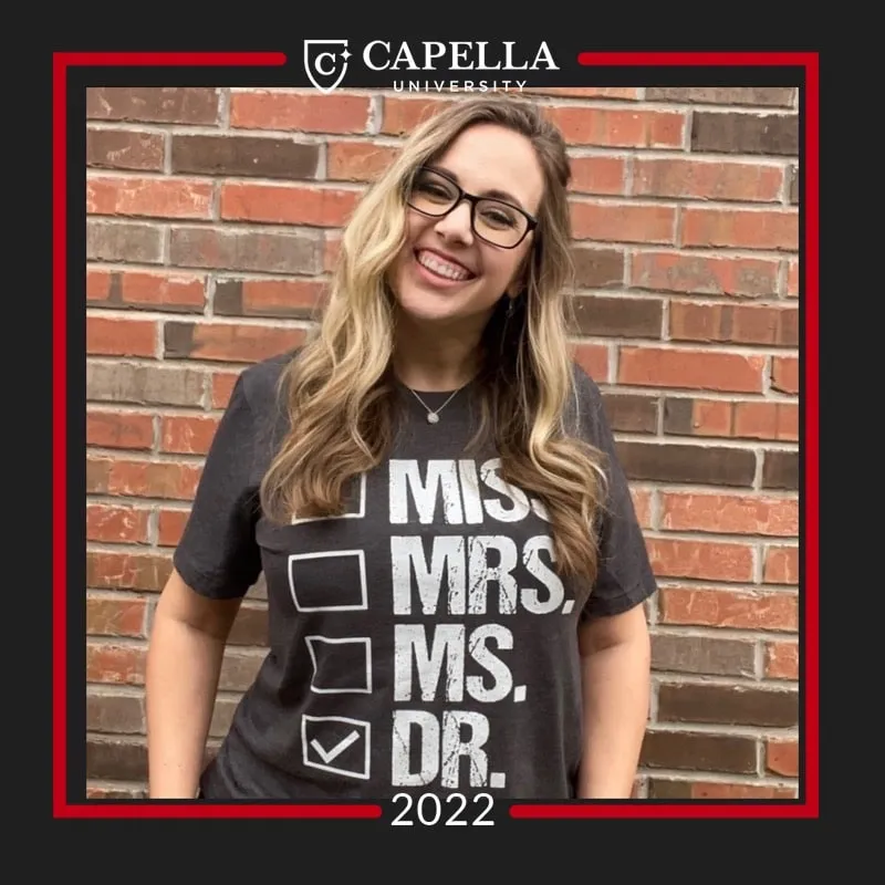 Photo booth snapshot of a graduate in a Miss Mrs Ms Dr checklist shirt on a Capella University 2022 frame