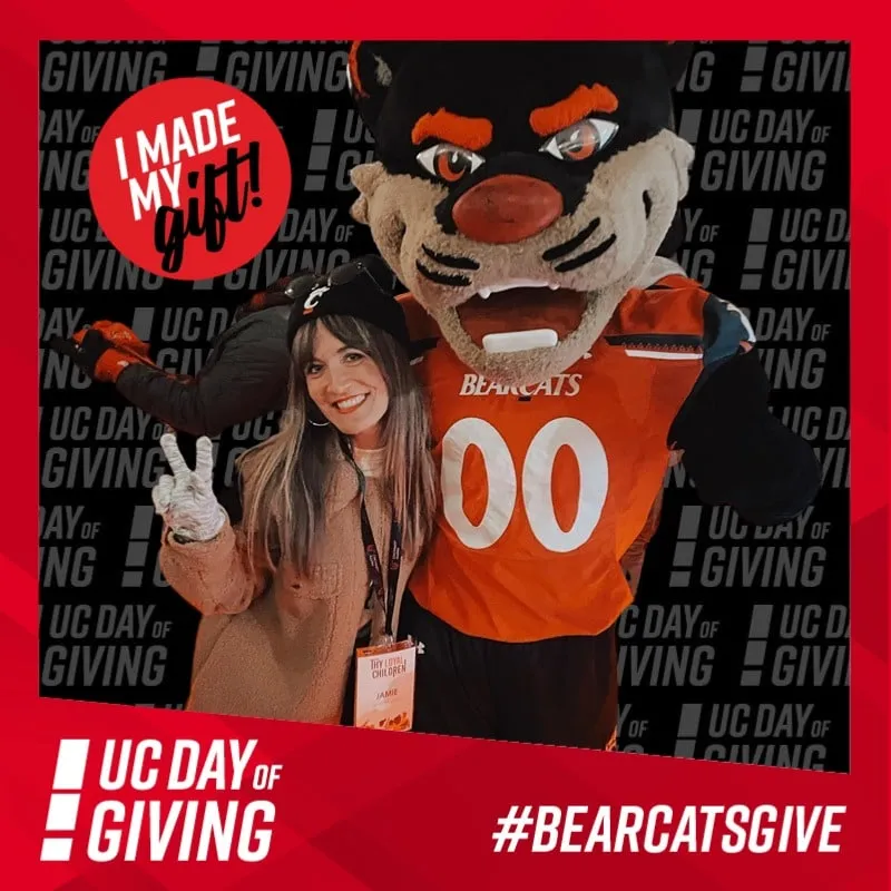 Photo booth snapshot of a guest posing with the Bearcat mascot on an I Made My Gift UC Day of Giving frame