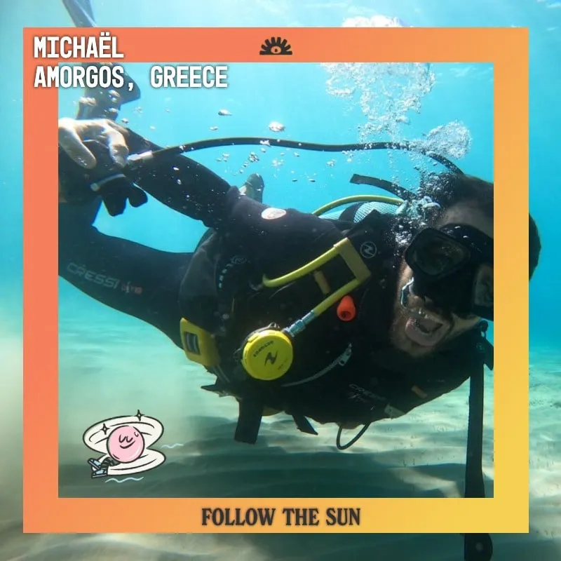 Photo booth snapshot of a scuba diver waving underwater on a Follow the Sun frame from Amorgos, Greece