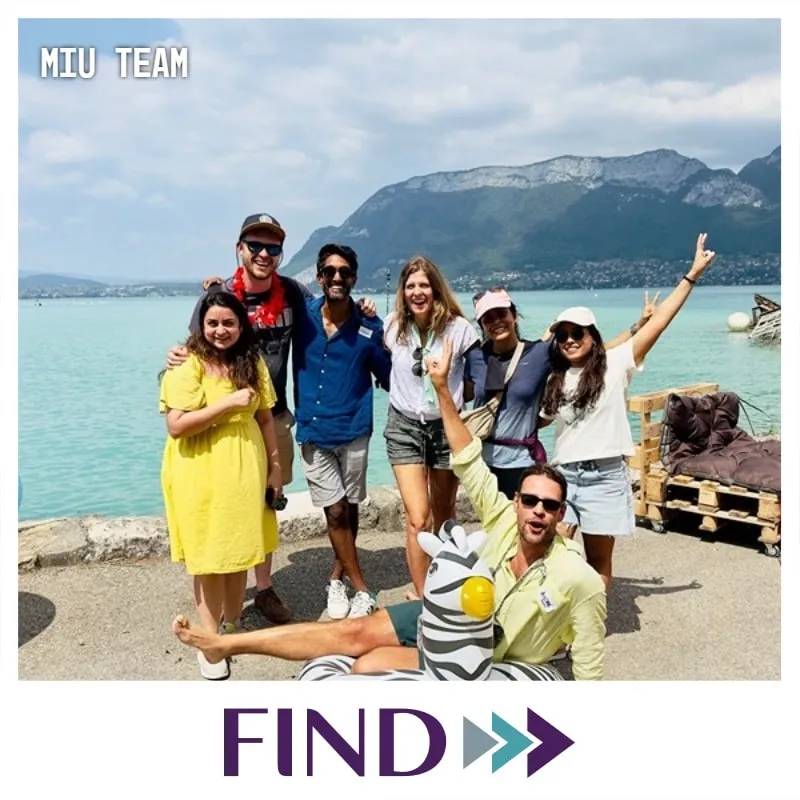 Photo booth snapshot of a team by a mountain lake with a zebra costume on a FIND frame