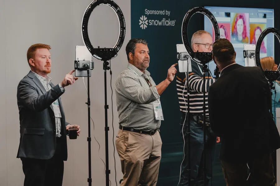 Three ring-light tablet capture stations running side by side at a conference activation, with guests using each one at the same time