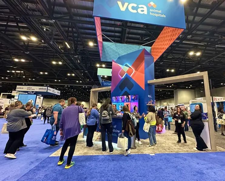 VCA Animal Hospitals booth at NAVC VMX 2025 with attendees gathered around a tall branded tower and a screen showing AI pet portraits