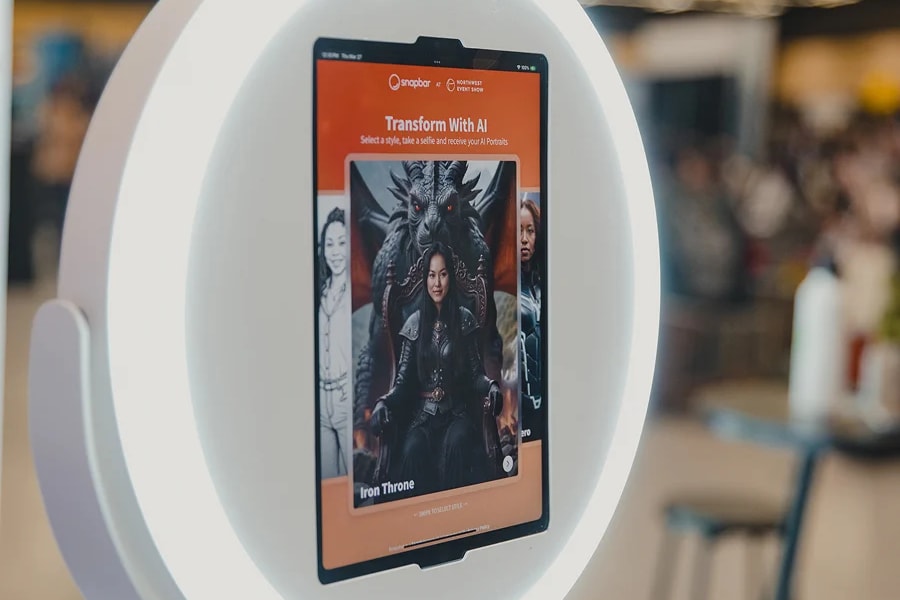 An iPad mounted in a white circular stand showing a branded AI transformation screen at an event
