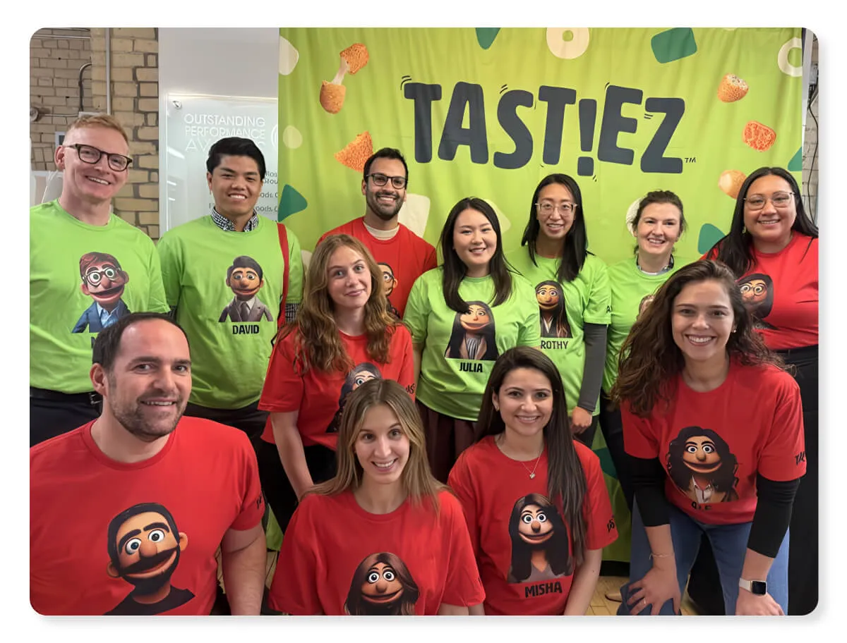 The Tast!ez team in front of a Tast!ez banner, wearing t-shirts printed with their AI character portraits