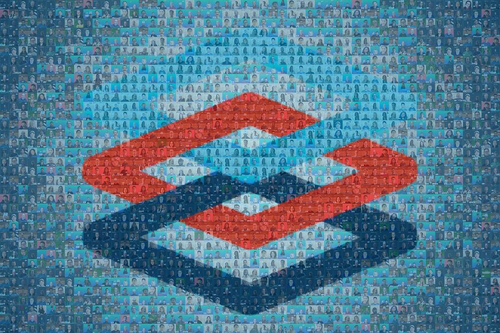 Blue photo mosaic of employee headshots forming an interlocking red and navy Capital One logo