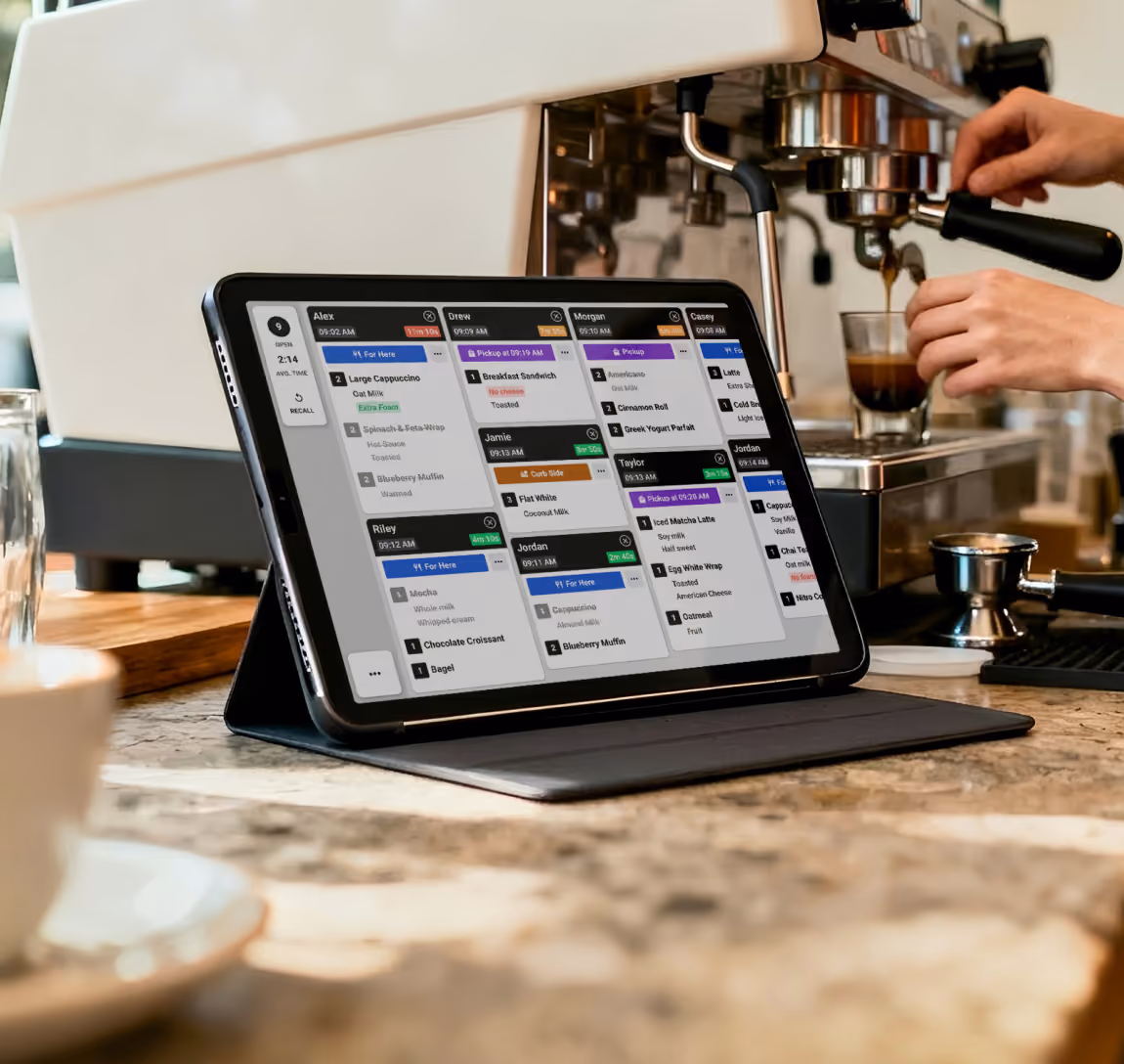 Fresh KDS screen showing multiple coffee orders next to a barista preparing espresso.
