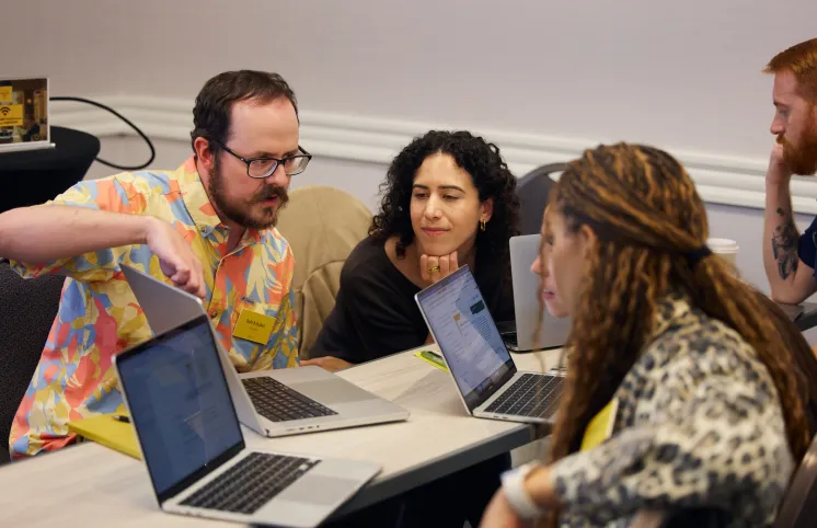 HQ team members around a table with their laptops