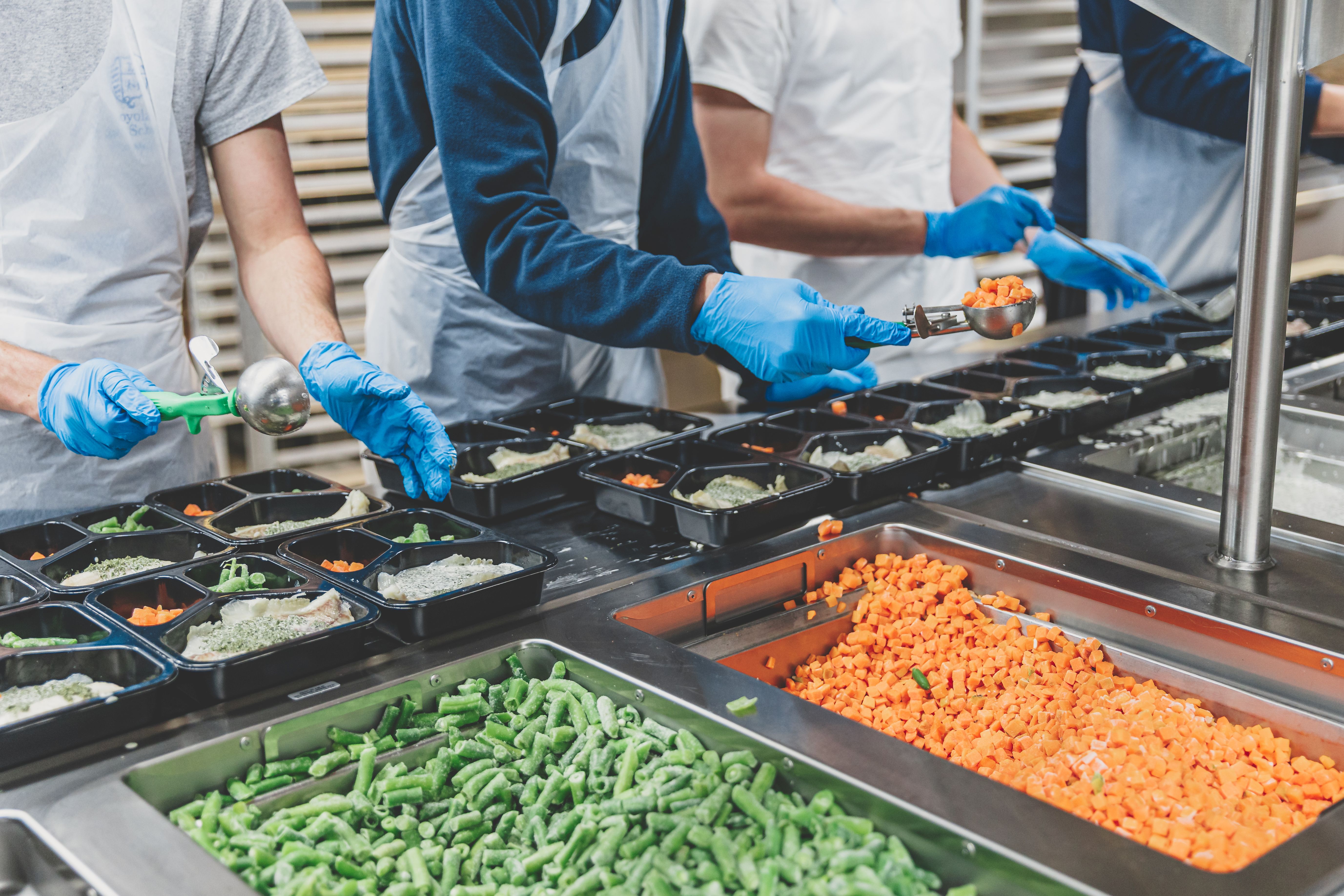 Volunteers packaging meals for delivery