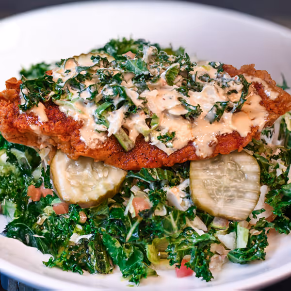 Nashville Hot Chicken Sandwich over a bed of house tossed greens
