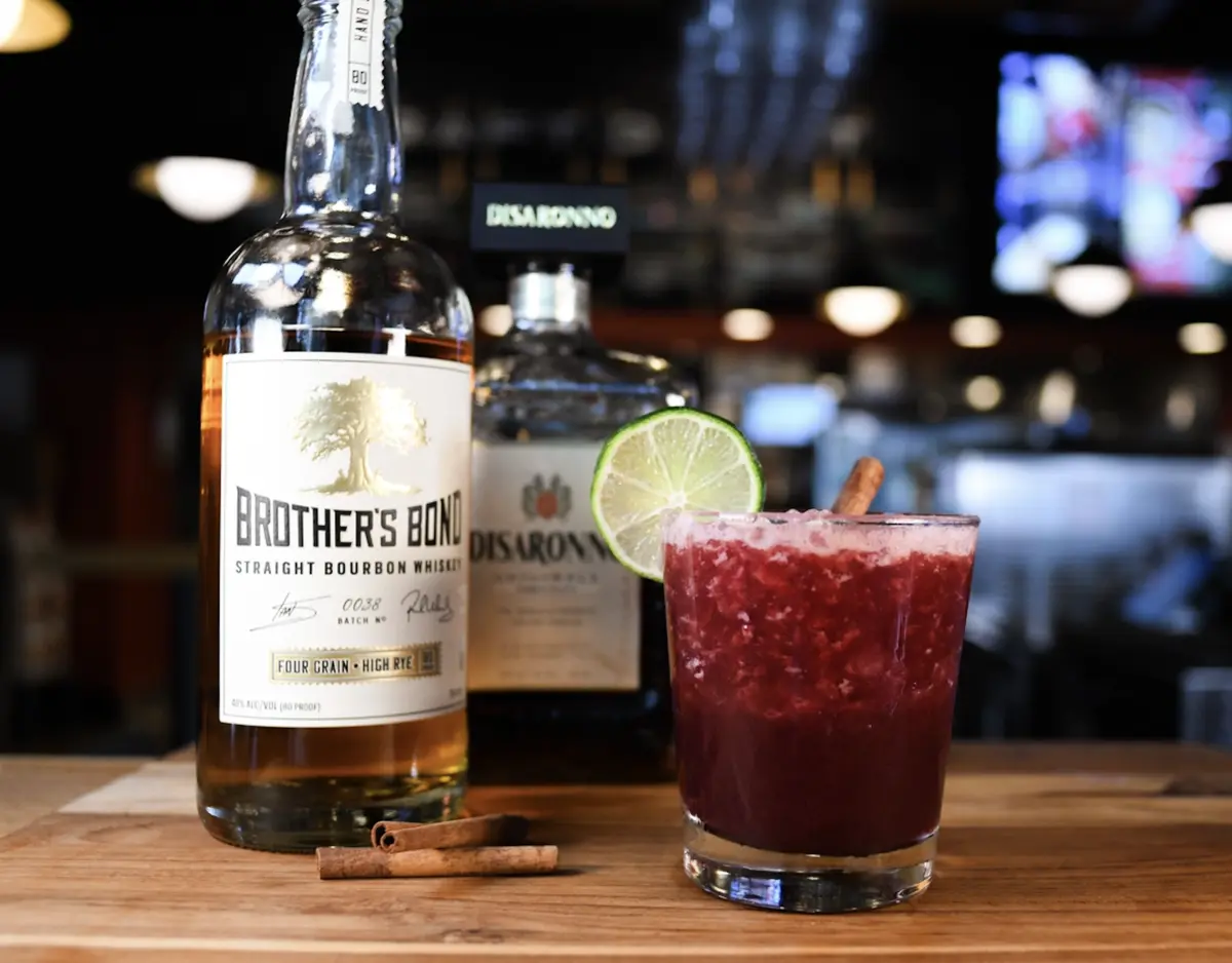 Holiday Sour cocktail featuring Brother's Bond Bourbon, Disaronno Italian Liqueur & black cherry puree.