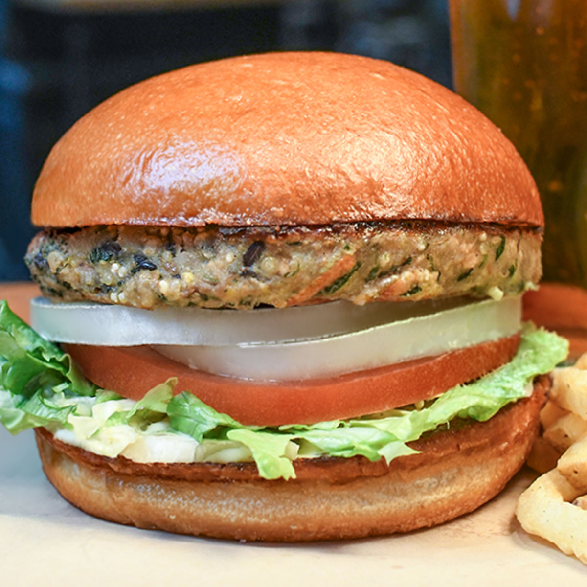 Veggie burger topped with lettuce, tomato, onion & mayo