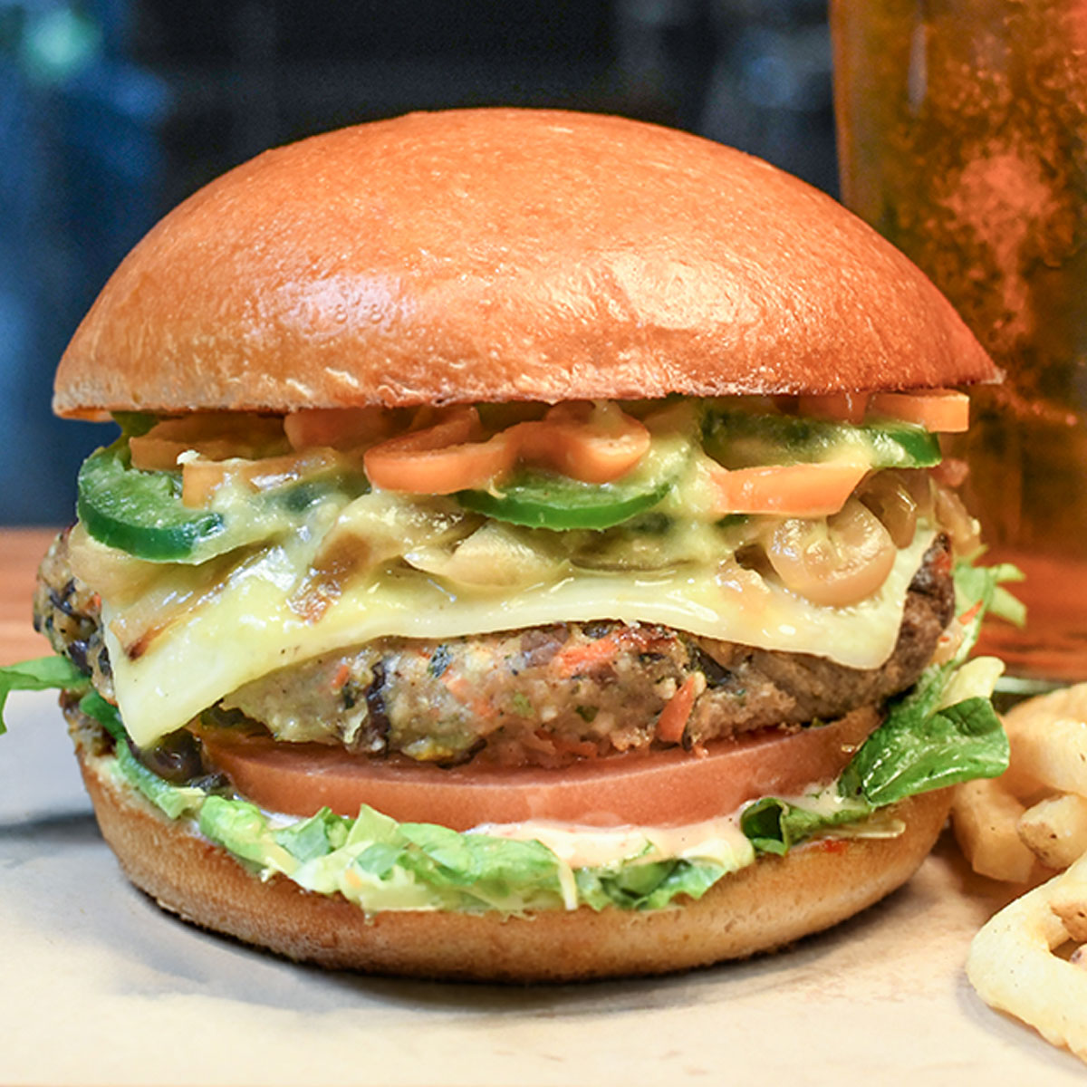 Veggie burger topped with pepper jack cheese, jalapeños & habaneros, caramelized onions, spicy salsa verde, lettuce, tomato & chipotle aioli sauce.