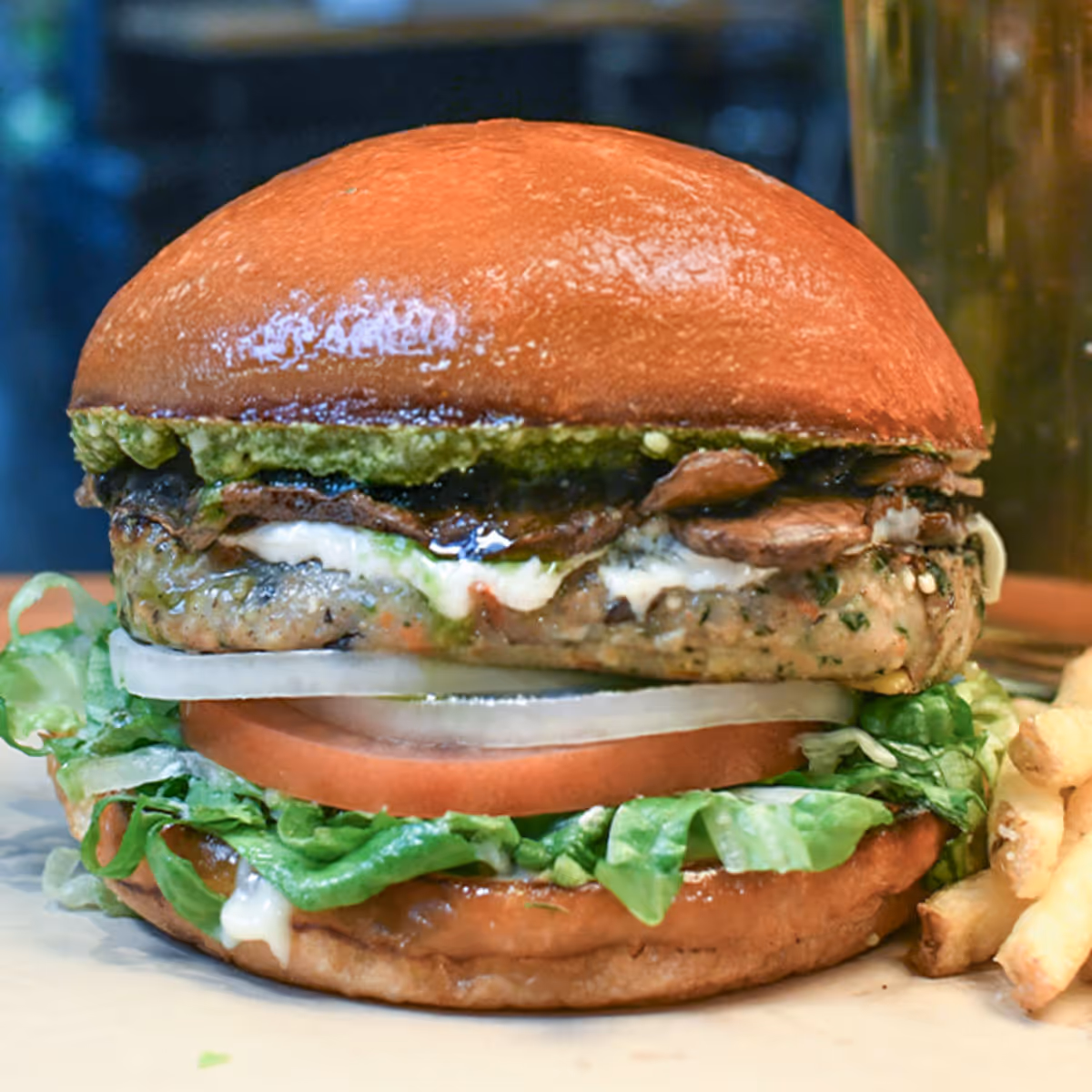 Veggie burger topped with creamy goat cheese, field mushrooms, lettuce, tomato, onion, mayo & basil pesto.