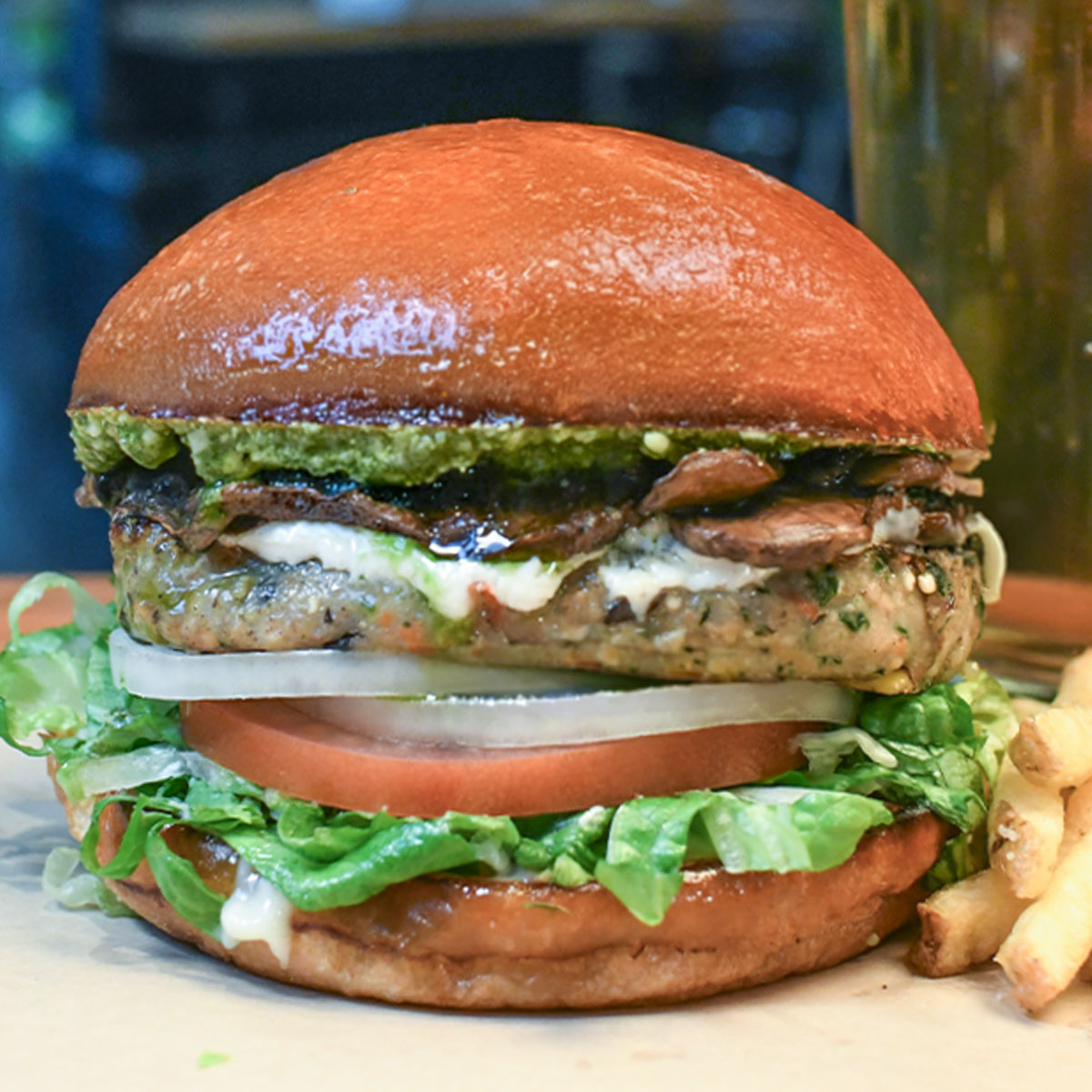 Veggie burger topped with creamy goat cheese, field mushrooms, lettuce, tomato, onion, mayo & basil pesto.