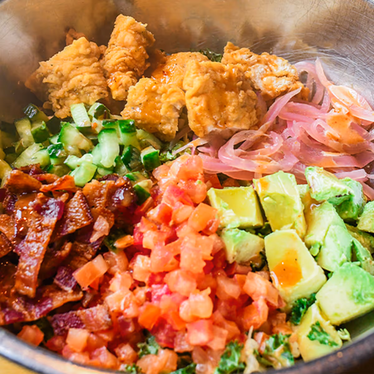 House greens tossed in a spicy honey mustard dressing, chopped crispy chicken tenders, steakhouse bacon, tomatoes, cucumber, pickled red onion & avocado.