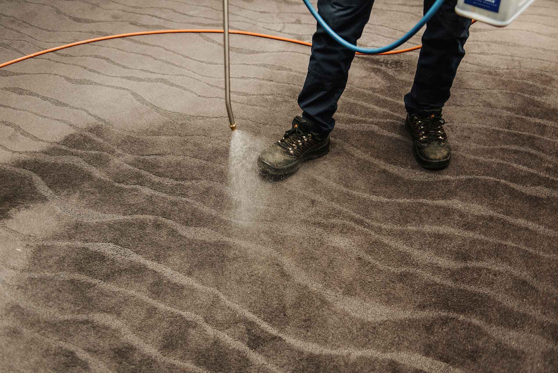 A water host pouring water on the carpet